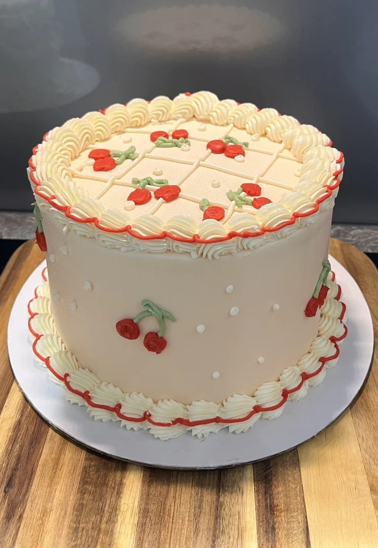 Buttercream birthday cake with cream and cherries