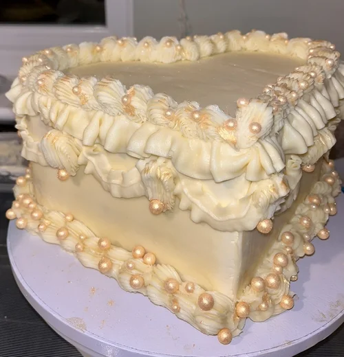 Heart-shaped birthday cake with gold pearls