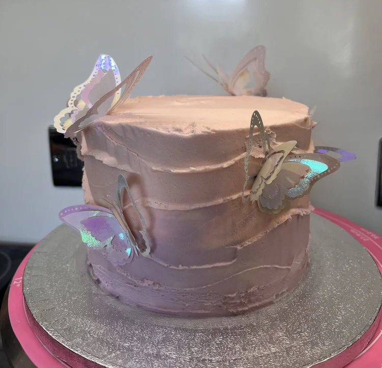 Pink birthday cake with paper butterflies