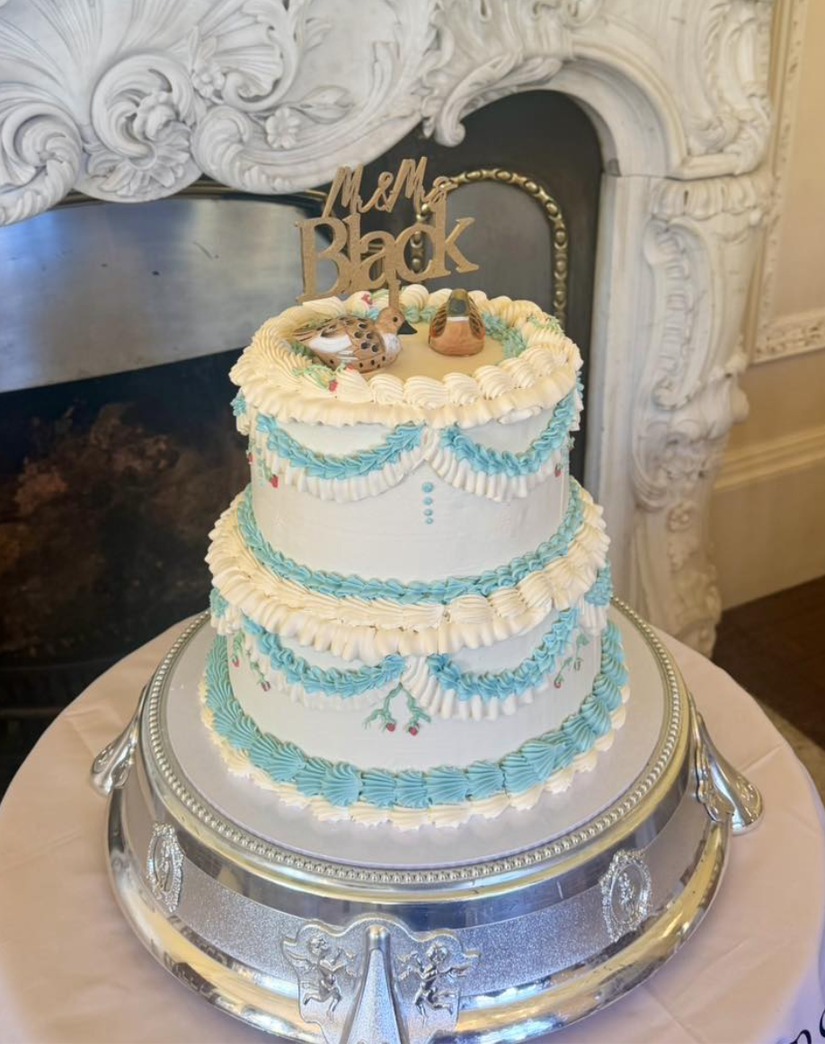 Wedding cake with blue and white decorations and cherries