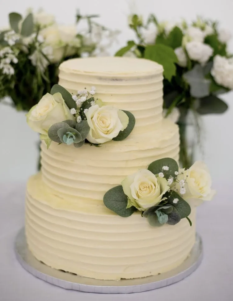 Three-tiered white wedding cake with roses